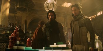 Movie still from “Men in Black: International” (2019), directed by F. Gary Gray – A man standing next to another man in a room; Medium shot, Low angle