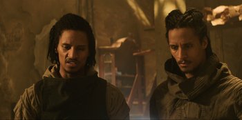 Movie still from “Men in Black: International” (2019), directed by F. Gary Gray – Two men standing next to each other in front of a wooden horse; Close Up shot, Low angle