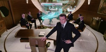 Movie still from “Men in Black: International” (2019), directed by F. Gary Gray – A man in a suit and tie standing in front of a group of people; Wide shot, Low angle