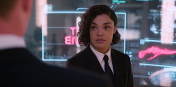 Movie still from “Men in Black: International” (2019), directed by F. Gary Gray – A woman in a suit and tie in front of a computer screen; Close Up shot, Over the shoulder angle
