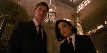 Movie still from “Men in Black: International” (2019), directed by F. Gary Gray – A man and a woman dressed in business suits; Medium shot, Low angle
