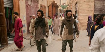 Movie still from “Men in Black: International” (2019), directed by F. Gary Gray – A group of people walking down a street; Medium shot, Over the shoulder angle