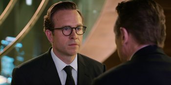 Movie still from “Men in Black: International” (2019), directed by F. Gary Gray – A man in a suit and tie talking to another man; Close Up shot, Over the shoulder angle