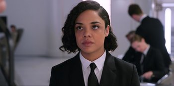 Movie still from “Men in Black: International” (2019), directed by F. Gary Gray – A woman in a suit and a tie; Close Up shot, Over the shoulder angle