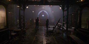 Movie still from “Men in Black: International” (2019), directed by F. Gary Gray – Two people are standing in the dark in a building; Wide shot, Low angle