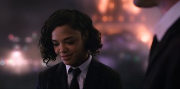 Movie still from “Men in Black: International” (2019), directed by F. Gary Gray – A woman in a suit and tie looking to her left; Close Up shot, Over the shoulder angle