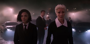 Movie still from “Men in Black: International” (2019), directed by F. Gary Gray – A group of people standing in the dark; Medium shot, Over the shoulder angle