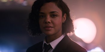 Movie still from “Men in Black: International” (2019), directed by F. Gary Gray – A woman in a suit and tie in front of a blurry background; Close Up shot, Low angle