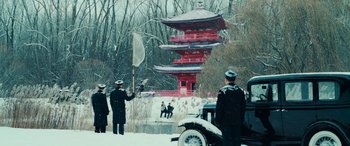 Movie still from “Midway” (2019), directed by Roland Emmerich – A group of men standing around a building in the snow; Extreme Wide shot, High angle