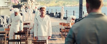 Movie still from “Midway” (2019), directed by Roland Emmerich – A man in a sailor's outfit standing on a pier; Medium shot, Over the shoulder angle