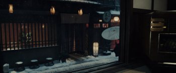 Movie still from “Midway” (2019), directed by Roland Emmerich – A person holding an umbrella in front of a window; Medium shot, High angle