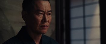 Movie still from “Midway” (2019), directed by Roland Emmerich – An older asian man looking at the camera; Close Up shot, Over the shoulder angle