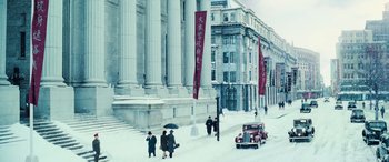 Movie still from “Midway” (2019), directed by Roland Emmerich – A group of people walking down a street in front of a building; Extreme Wide shot, High angle
