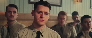 Movie still from “Midway” (2019), directed by Roland Emmerich – A man in a tan shirt and a black tie; Close Up shot, Over the shoulder angle