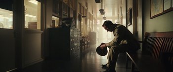 Movie still from “Midway” (2019), directed by Roland Emmerich – A man sitting on a bench holding a frisbee; Wide shot, Low angle