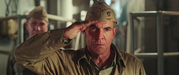 Movie still from “Midway” (2019), directed by Roland Emmerich – A man saluting while wearing an army hat; Close Up shot, Low angle