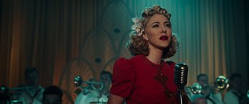 Movie still from “Midway” (2019), directed by Roland Emmerich – A woman in a red dress with a flower in her hair; Close Up shot, Low angle