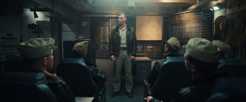 Movie still from “Midway” (2019), directed by Roland Emmerich – A group of men sitting in a room; Medium shot, Low angle