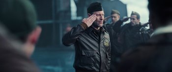 Movie still from “Midway” (2019), directed by Roland Emmerich – A man saluting while wearing a leather jacket; Medium shot, Low angle