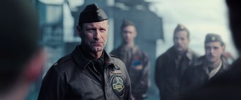 Movie still from “Midway” (2019), directed by Roland Emmerich – A man in a military uniform standing next to another man in a uniform; Close Up shot, Low angle