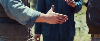 Movie still from “Midway” (2019), directed by Roland Emmerich – Two people are shaking hands in a field; Extreme Close Up shot, Over the shoulder angle