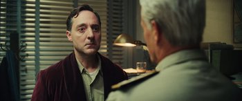 Movie still from “Midway” (2019), directed by Roland Emmerich – A man is looking at another man in front of a lamp; Close Up shot, Low angle