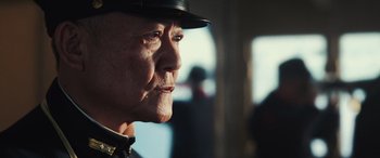 Movie still from “Midway” (2019), directed by Roland Emmerich – An older man wearing a hat looking off into the distance; Close Up shot, Low angle