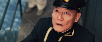 Movie still from “Midway” (2019), directed by Roland Emmerich – An older man wearing a uniform and a hat; Close Up shot, Low angle