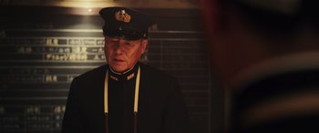 Movie still from “Midway” (2019), directed by Roland Emmerich – A man in a uniform is standing in a dark room; Close Up shot, Low angle