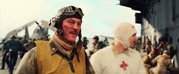 Movie still from “Midway” (2019), directed by Roland Emmerich – A man wearing a helmet and goggles and wearing a pilot's uniform; Close Up shot, Low angle