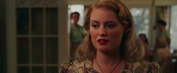 Movie still from “Midway” (2019), directed by Roland Emmerich – A woman with blonde curly hair and red lipstick looking to her left; Close Up shot, Over the shoulder angle