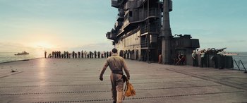 Movie still from “Midway” (2019), directed by Roland Emmerich – A man walking across a dock with a bag; Wide shot, Low angle