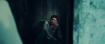 Movie still from “Midway” (2019), directed by Roland Emmerich – A man sitting on the ground in a dark room; Medium shot, High angle