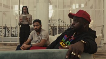 Movie still from “Atlanta” (2016), created by Donald Glover – Two men and a woman are sitting in a room; Medium shot, Over the shoulder angle