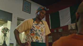 Movie still from “Atlanta” (2016), created by Donald Glover – A woman wearing an apron standing in front of a table; Medium shot, Over the shoulder angle