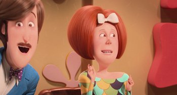 Movie still from “Minions” (2015), directed by Pierre Coffin – An animated woman with red hair and a white bow in her hair; Close Up shot, Over the shoulder angle