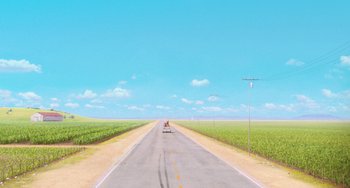 Movie still from “Minions” (2015), directed by Pierre Coffin – A person riding a skateboard down the side of a road; Extreme Wide shot, High angle