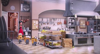 Movie still from “Minions” (2015), directed by Pierre Coffin – A kitchen scene with bananas on a cart; Wide shot, High angle