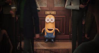 Movie still from “Minions” (2015), directed by Pierre Coffin – A minion standing in front of a door way; Wide shot, Over the shoulder angle
