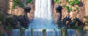 Movie still from “Minions: The Rise of Gru” (2022), directed by Jonathan del Val – A painting of a waterfall with two dragon statues; Extreme Wide shot, Overhead angle