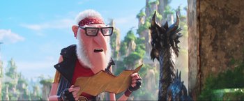 Movie still from “Minions: The Rise of Gru” (2022), directed by Jonathan del Val – An old man holding a piece of paper next to a dragon; Close Up shot, Over the shoulder angle