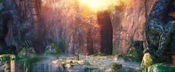 Movie still from “Minions: The Rise of Gru” (2022), directed by Jonathan del Val – Two people are sitting on a bench in front of a cave; Extreme Wide shot, Low angle