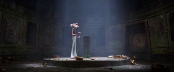 Movie still from “Minions: The Rise of Gru” (2022), directed by Jonathan del Val – A person standing on a stage holding a whip; Wide shot, Low angle