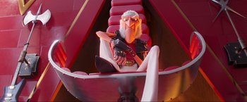 Movie still from “Minions: The Rise of Gru” (2022), directed by Jonathan del Val – A person sitting in a chair; Medium shot, Low angle