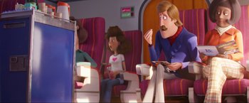 Movie still from “Minions: The Rise of Gru” (2022), directed by Jonathan del Val – A man sitting on a chair in front of a woman; Medium shot, Over the shoulder angle