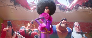 Movie still from “Minions: The Rise of Gru” (2022), directed by Jonathan del Val – A woman in a purple outfit with a large afro; Medium shot, Low angle