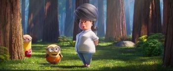 Movie still from “Minions: The Rise of Gru” (2022), directed by Jonathan del Val – A woman standing next to a minion in the woods; Medium shot, Low angle
