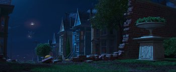 Movie still from “Minions: The Rise of Gru” (2022), directed by Jonathan del Val – A row of houses on a street at night time; Extreme Wide shot, Low angle