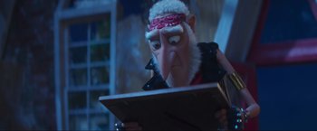 Movie still from “Minions: The Rise of Gru” (2022), directed by Jonathan del Val – An animated character is reading a book in a dark room; Close Up shot, Over the shoulder angle