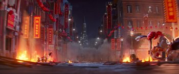 Movie still from “Minions: The Rise of Gru” (2022), directed by Jonathan del Val – A city street filled with lots of smoke and red lights; Extreme Wide shot, High angle
